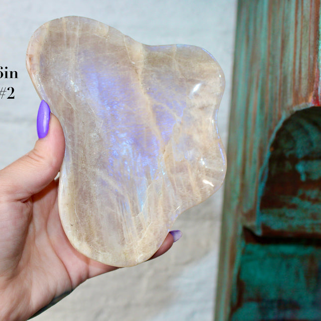 This Moonstone Bowl is carved from natural stone and polished to reveal stunning blue flash across its surface. Its compact size and elegant shine make it both functional and decorative ideal for adding a touch of iridescence to any space