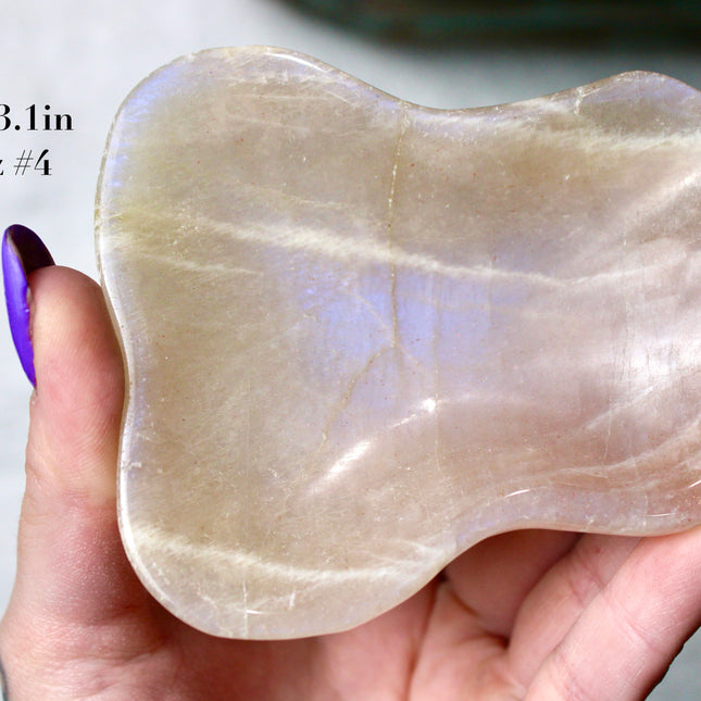 This Moonstone Bowl is carved from natural stone and polished to reveal stunning blue flash across its surface. Its compact size and elegant shine make it both functional and decorative ideal for adding a touch of iridescence to any space