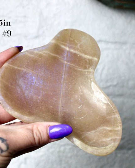 This Moonstone Bowl is carved from natural stone and polished to reveal stunning blue flash across its surface. Its compact size and elegant shine make it both functional and decorative ideal for adding a touch of iridescence to any space