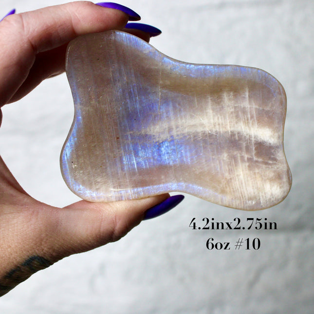 This Moonstone Bowl is carved from natural stone and polished to reveal stunning blue flash across its surface. Its compact size and elegant shine make it both functional and decorative ideal for adding a touch of iridescence to any space