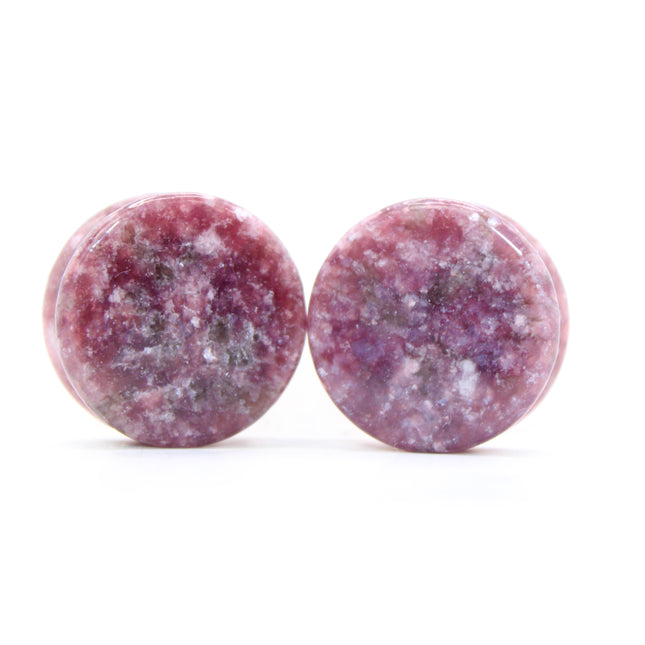 Round purple jasper plugs on a white background