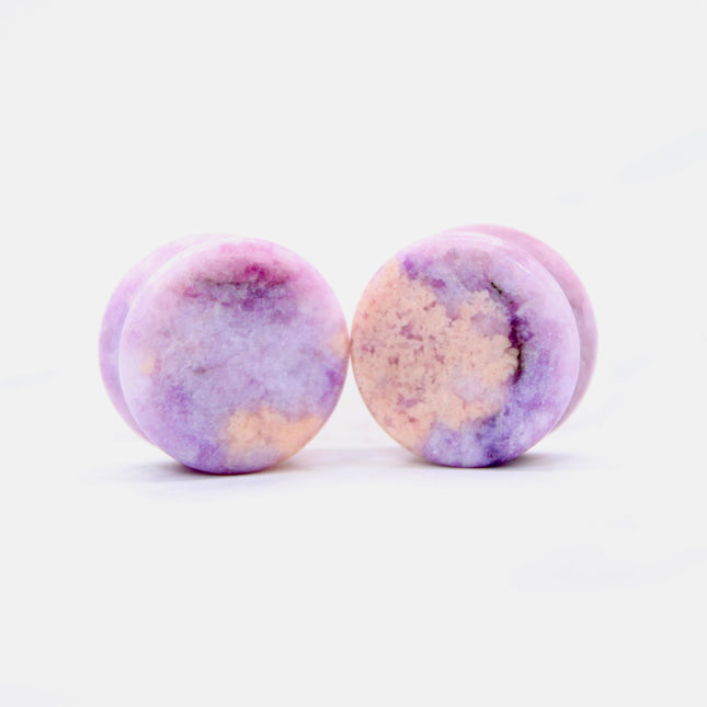 Round purple jasper plugs on a white background