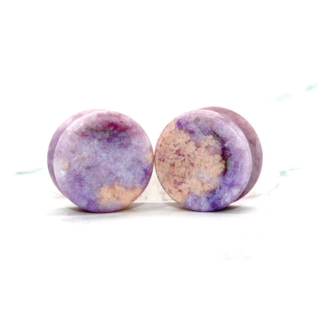 Round purple jasper plugs on a white background