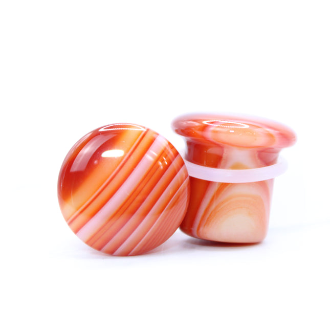 These single flare plugs are carved from genuine Carnelian Agate, showcasing warm, fiery hues and occasional natural banding or translucent zones. Hand-polished to a sleek finish, each plug is smooth and comfortable for everyday wear.