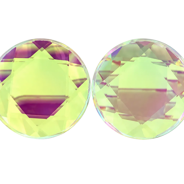 Two round, faceted clear glass plugs with an iridescent, holographic finish, one standing vertically and the other lying horizontally, on a white background.