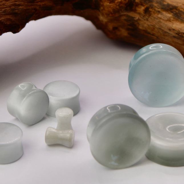 A sleek and shimmering pair of Silver Cat's Eye glass plugs, crafted with precision and finished to a flawless polish. These double flare plugs feature a metallic silver sheen with a mesmerizing “cat’s eye” effect—an optical reflection that shifts with the light, creating a glowing, fiber-optic-like line across the center. Smooth and lightweight, each plug offers a comfortable, secure fit ideal for daily wear.