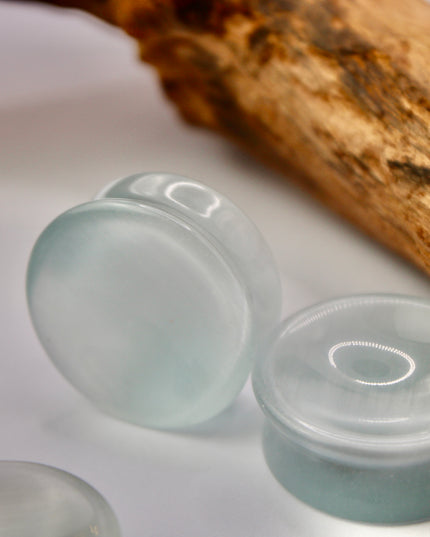 A sleek and shimmering pair of Silver Cat's Eye glass plugs, crafted with precision and finished to a flawless polish. These double flare plugs feature a metallic silver sheen with a mesmerizing “cat’s eye” effect—an optical reflection that shifts with the light, creating a glowing, fiber-optic-like line across the center. Smooth and lightweight, each plug offers a comfortable, secure fit ideal for daily wear.