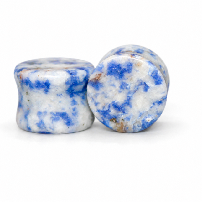 Two polished blue and white marbled stone plugs standing upright on a white background.