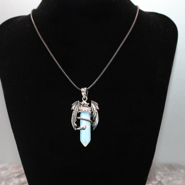 A fierce and enchanting Dragon Necklace with Opalite brings fantasy to life, featuring a detailed dragon wrapped protectively around a glowing opalite orb. The iridescent stone shimmers with soft hues of blue, lavender, and pearly white, catching light with a mystical glow. The dragon pendant is crafted with intricate scales and wings, giving it a bold, medieval-inspired aesthetic.