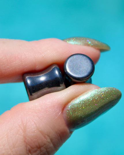 Crafted from polished natural hematite, these plugs offer a sleek, metallic finish with a cool, gunmetal-gray sheen. Smooth and weighty, hematite plugs provide a comfortable fit while giving off a bold, minimalist look. Known for its grounding and balancing properties, hematite is a favorite among those who seek both style and energetic stability. Ideal for stretched ears, these plugs combine natural beauty with a modern edge.