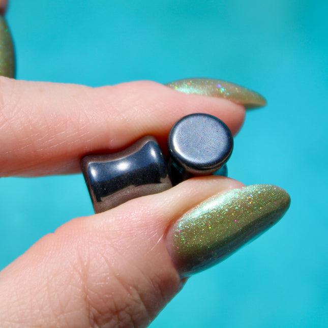 Crafted from polished natural hematite, these plugs offer a sleek, metallic finish with a cool, gunmetal-gray sheen. Smooth and weighty, hematite plugs provide a comfortable fit while giving off a bold, minimalist look. Known for its grounding and balancing properties, hematite is a favorite among those who seek both style and energetic stability. Ideal for stretched ears, these plugs combine natural beauty with a modern edge.