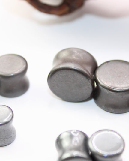 Crafted from polished natural hematite, these plugs offer a sleek, metallic finish with a cool, gunmetal-gray sheen. Smooth and weighty, hematite plugs provide a comfortable fit while giving off a bold, minimalist look. Known for its grounding and balancing properties, hematite is a favorite among those who seek both style and energetic stability. Ideal for stretched ears, these plugs combine natural beauty with a modern edge.