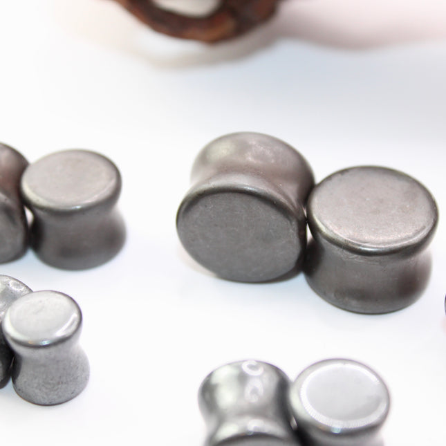 Crafted from polished natural hematite, these plugs offer a sleek, metallic finish with a cool, gunmetal-gray sheen. Smooth and weighty, hematite plugs provide a comfortable fit while giving off a bold, minimalist look. Known for its grounding and balancing properties, hematite is a favorite among those who seek both style and energetic stability. Ideal for stretched ears, these plugs combine natural beauty with a modern edge.