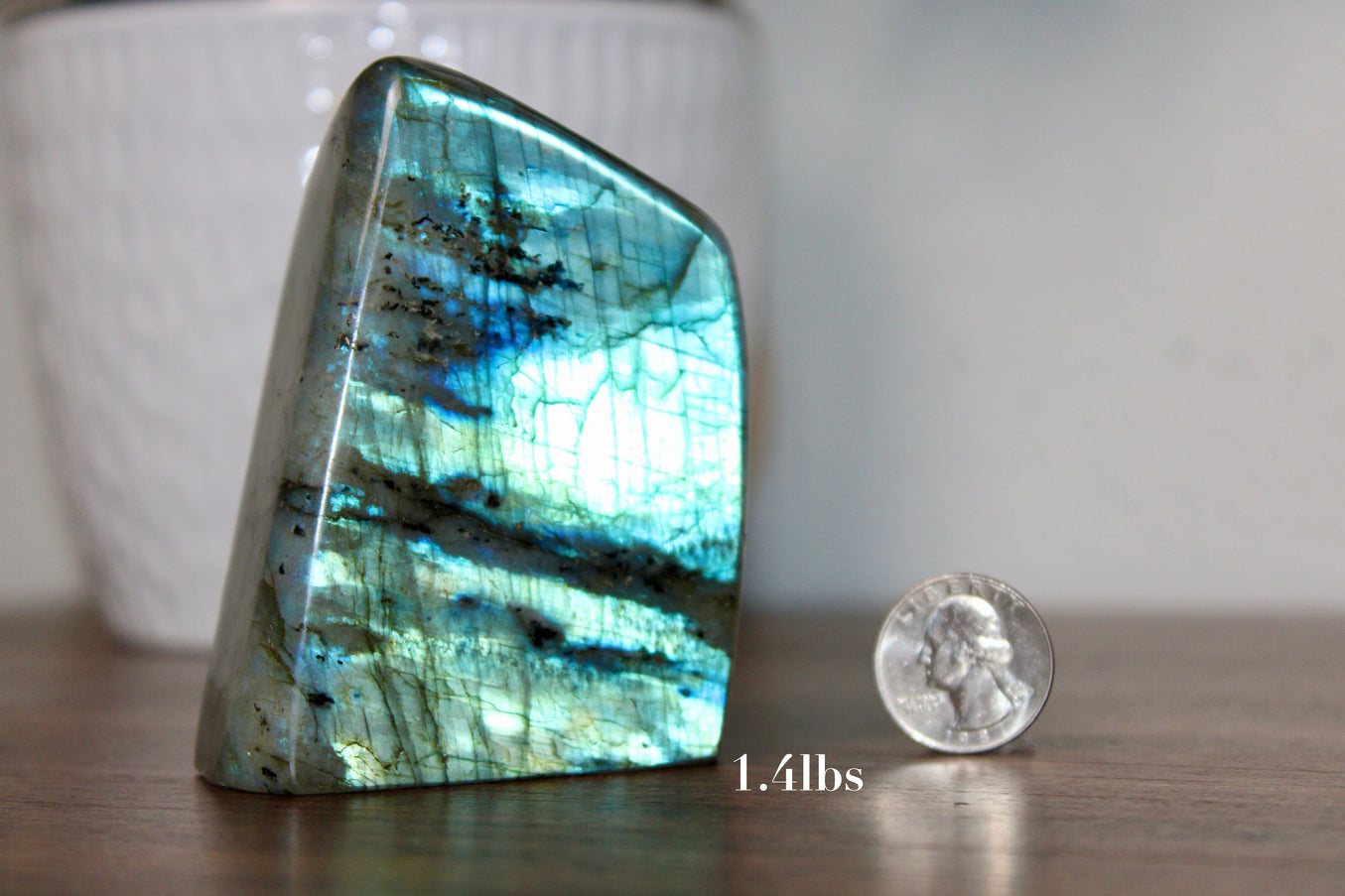 A radiant collection of Labradorite High Flash Free Forms is displayed on a soft, natural-toned surface, each piece glowing with brilliant iridescence. These freeform stones come in various shapes and sizes, but all share one captivating feature: a bold, high-flash display that shifts with light—showcasing vibrant blues, greens, golds, and even rare hints of purple or teal. The polished surfaces reveal the natural magic within each labradorite, while the raw backs or edges add an earthy contrast. Each piece