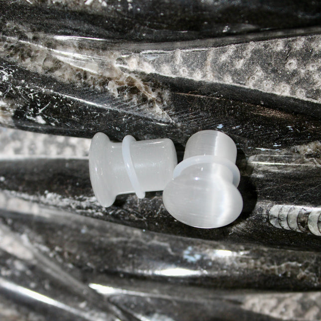 Silver Cat’s Eye glass is known for its sophisticated shimmer and luminous, moving line—known as chatoyancy—that dances across the surface like a beam of light. The cool, metallic tone represents clarity, balance, and subtle strength, making it a versatile choice for everyday wear or a sleek accent piece.